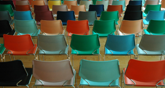 rows of coloured chairs in a hallway, viewed from behind)