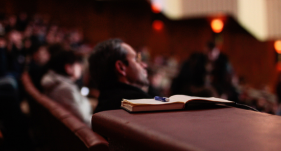 People Listening To Speakers in an auditorium)