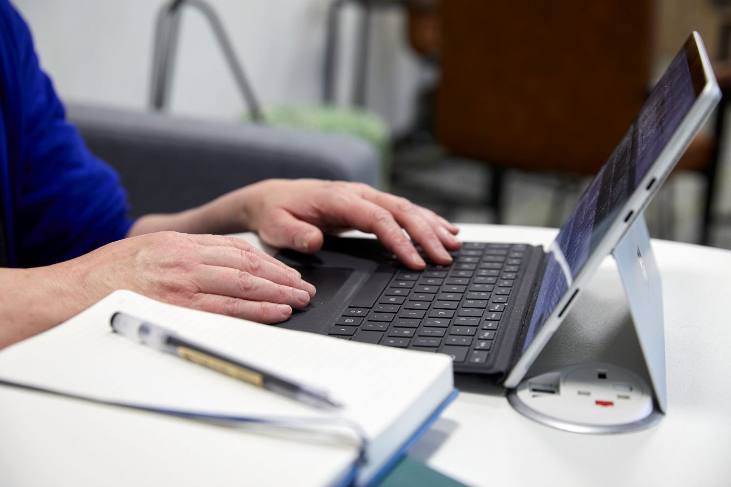 Hands typing on a laptop