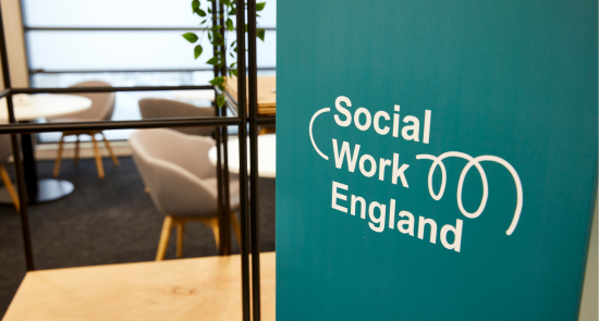 Social Work England banner in front of table and chairs)
