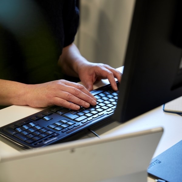 Hands typing on computer