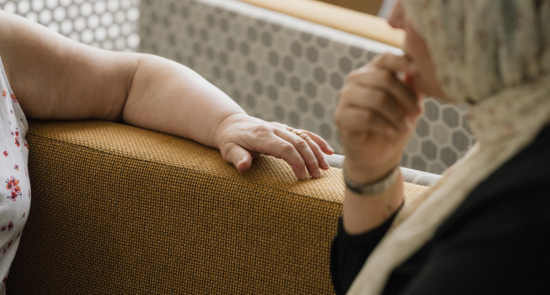 Two people sat on a sofa facing each other)