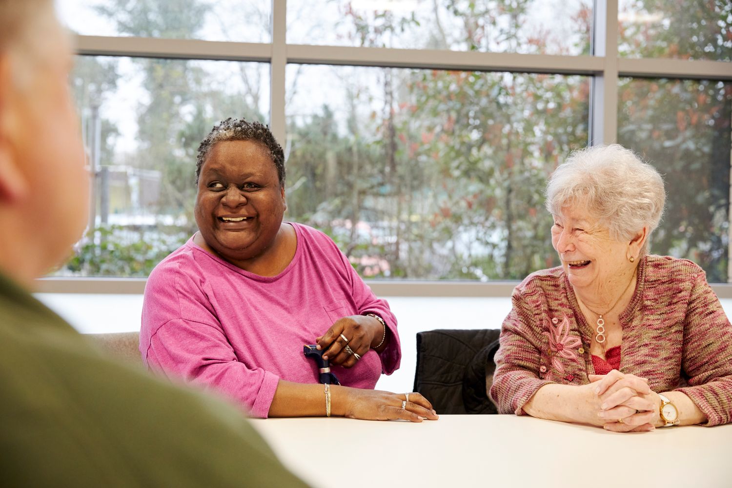 Two women sat at a table, smiling.