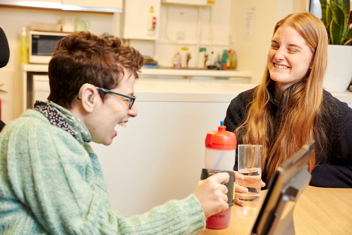 Two people sat at a table, laughing