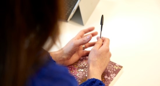 Woman's hands holding pen)