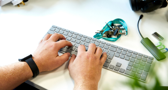 Hands typing on a keyboard)