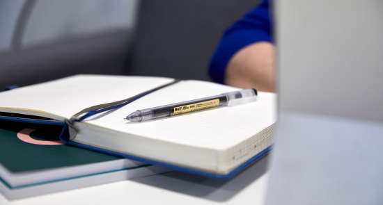A pen and notebook on a table)